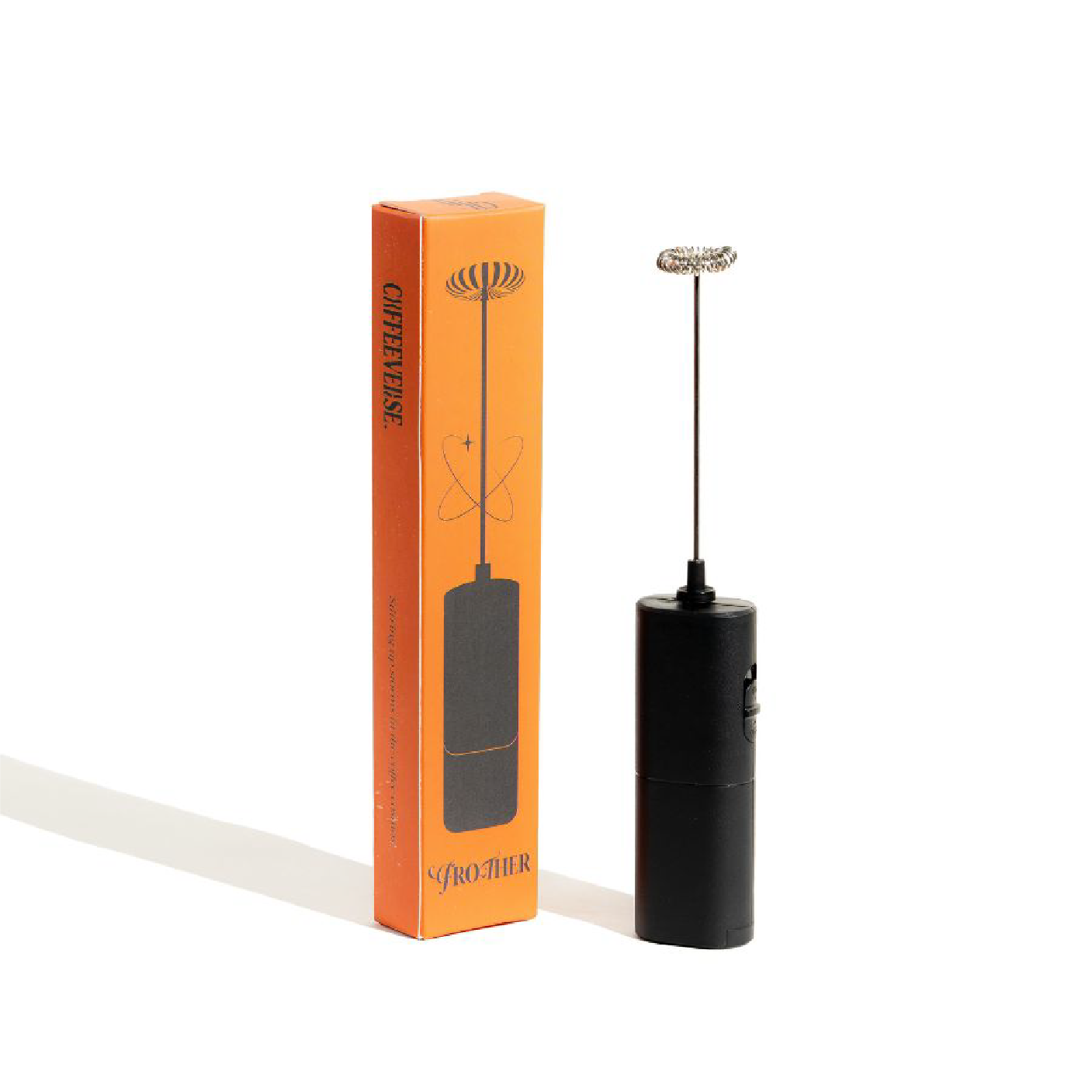 Black milk frother with orange packaging on a white background