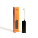 Black milk frother with orange packaging on a white background